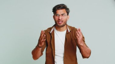 - Ne? - Neden? Kızgın Hintli adam öfkeli bir ifadeyle el kaldırıyor, başarısızlık nedenini soruyor, sorunlardan kuşkulandığını gösteriyor. Gri stüdyo arka planında izole Arap genç adam