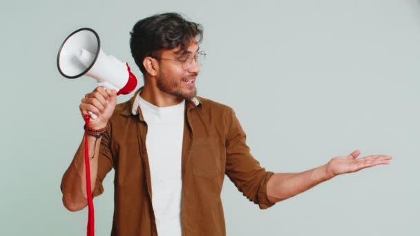 印度年轻人用扩音器说话 宣布新闻 大声宣布广告折扣销售 用扩音器大声疾呼 快乐的阿拉伯人被隔离在工作室灰色背景中 — 图库视频影像