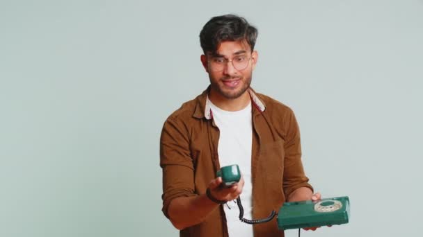電話してくれ インドの若者は80年代の有線ランドラインのヴィンテージ電話で話し 会話の広告提案 オンラインショッピング ホットライン 灰色の背景に孤立したアラビアの男 — ストック動画