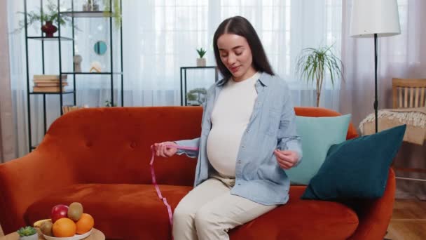 Femeia Însărcinată Zâmbind Canapea Măsurând Burta Bandă Măsură Tânăra Viitoare — Videoclip de stoc