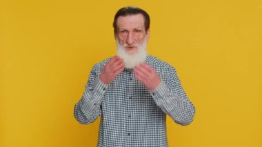 Hiçbir şey söylemeyeceğim. Korkmuş kıdemli adam elleriyle ağzını kapatıyor, kamera karşısında korkmuş görünüyor. Gizli inanılmaz gerçeği söylemeyi reddetmiyor. Büyükbaba sarı arka planda.