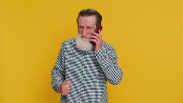 好消息 老人高兴极了 他在智能手机上谈笑风生 喜欢和家人聊天 长胡子的爷爷 黄种人背景 — 图库视频影像