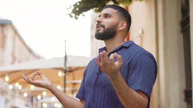 Sakin ol, sakin ol. Hintli adam dua ediyor, derin derin nefes alıyor, gözleri kapalı, konsantre düşüncelerle meditasyon yapıyor, dışarıda huzurlu bir zihin. Yetişkin adam şehir caddesinde mola veriyor.