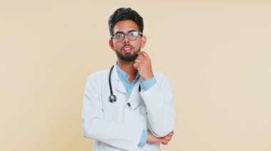 Evreka. Hindistanlı genç doktor kardiyolog parmağını açık ağızla işaret ederek iyi bir fikir, plan, başlangıç, ilham motivasyon çözümüne sahip. Bej arka planda eczacı.