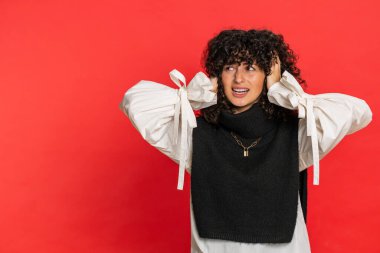 Duymak istemiyorum, dinle. Sinirli, sinirli, saçları kıvırcık, kulakları jest yapan genç bir kadın hayır diyor, nahoş sesleri görmezden gelerek tavsiye vermekten kaçınıyor. Kırmızı arkaplanda izole edilmiş kız