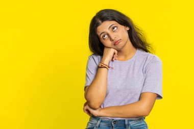 Hintli genç kadın kayıtsız kalmaktan sıkılmış, sıkıcı hikayelerden bıkmış, iletişim konuşmalarıyla ilgilenmeyen, hoşnutsuzlukla ilgilenmeyen, ilgisiz. Sarı arka planda izole edilmiş bir Arap kızı.