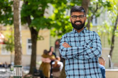 Hintli sakallı turist yazın şehir caddesinde yürüyor. İspanyol gezgin gülümsüyor ve tatilin tadını çıkarıyor. Kasaba yaşam tarzları. Yatay