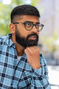 Üzgün, mutsuz, sakallı Hintli adam, açık havada adaletsiz bir durumdan muzdarip. Sorun, kötü hissetmek, sinirlenmek, tükenmek, keder. Şehir caddesinde oturan bunalımlı yalnız İspanyol adam. Dikey