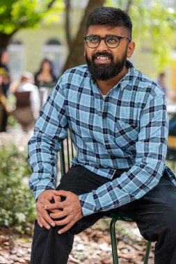 Hasta Hintli sakallı adam acı veren bir rahatsızlıktan muzdarip diz eklem ağrısı, bacak kasları, dışarıda yürüyemiyordu. İspanyol, üzgün, dizlerine masaj yapan hasta adam. Şehir sokaklarında romatizma krampı geçiriyor.