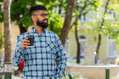 Mutlu Hintli sakallı adam sabah kahvesinin tadını çıkarıyor sıcak bir şeyler içiyor ve dışarıda gülümsüyor. Dinleniyorum, ara veriyorum. Şehir caddesinde yürüyen İspanyol adam kahve içiyor. Kasaba yaşam tarzları. Yatay