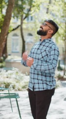 Hintli genç adam başarıyı kutluyor gol başarısını kazanıyor iyi haber piyango kumarhanesi açık havada şans zafer kariyeri. Şehir sokağındaki İspanyol adam. Kasaba yaşam tarzları. Dikey