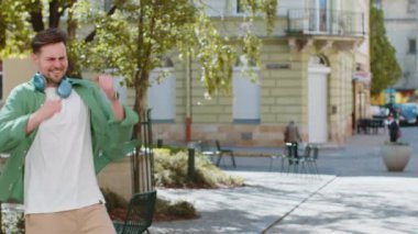 Heyecanlı mutlu gezgin bağırıyor, başarıyı kutluyor, kazanıyor, gol başarısı, iyi haber, piyango talihi, açık havada zafer. Şehir Güneşi Sokağı 'nda yürüyen genç bir adam. Yaşam Tarzları.