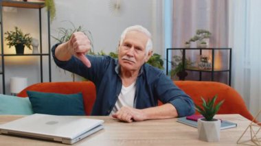 Hoşlanmamak. Mutsuz, son sınıf öğrencisi, işaret parmağı gösteren, hoşnutsuzluğunu dile getiren, evde çalışmaktan memnun olmayan mutsuz bir adam. Memnun olmayan yaşlı büyükbaba masada oturuyor.