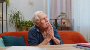 Lütfen, Tanrım yardım et. Endişeli kıdemli adam kollarını kavuşturup, içtenlikle sağlık için dua ediyor, yukarı bakıyor, umutlu bir şekilde özür diliyor. Yaşlı olgun büyükbaba.