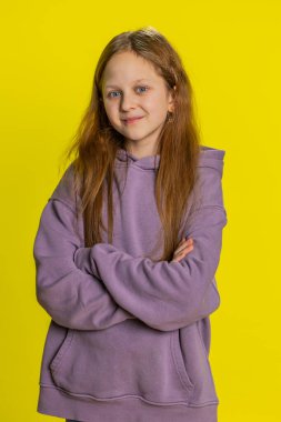 Genç ve mutlu bir kızın portresi. Arkadaşça gülümseyen, mutlu bir yüz ifadesi. Kameraya bakıp dinlenme hayali kuran rahatlama. Sarı arka planda genç çocuklar. Dikey