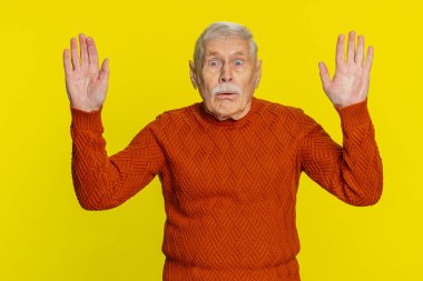 Aman Tanrım, vay canına. Heyecanlı kıdemli adam, büyük gözlerle kameraya bakarken şaşkınlıkla el kaldırıyor. Başarı başarısını kutlayan ani zaferden şok oluyor. Sarı üzerine olgun büyükbaba.