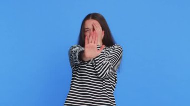 Buna bakmak istemiyorum, çok kötü. Korkmuş beyaz kadın çizgili bluz giymiş, gözlerini kapatmış, elinde dur işareti olan, kafası karışmış, utangaç, izlemeyi reddeden. Mavi arkaplanda izole edilmiş kız