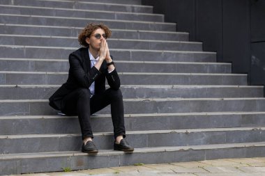 Gergin yönetici ofis merdivenlerinde oturuyor. Düşünceli takım elbiseli işadamı şirket kararına katıldı. Başarılı CEO, sessiz kalma konusunda uzman. Şirket lideri şehir merkezinde kafa yoruyor..