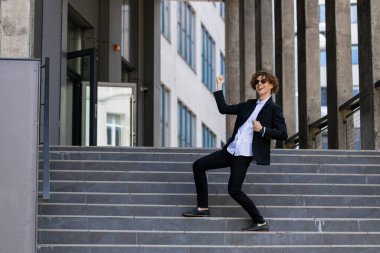 Dans, başarı ya da iş görüşmesi, terfi ya da kurumsal anlaşmadan sonra yürüyen adımlarla kutlama yapan iş adamı. Heyecanlı ya da mutlu dans çalışanı şehir merkezindeki satış hedeflerini ya da hedeflerini kutluyor.