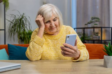 Son sınıf öğrencisi kadın akıllı telefon daktilo kullanıyor. Ani piyango sonuçlarını kaybediyor. Kötü haber, servet kaybı, başarısızlık. Evde oturma odasında yaşlı bir büyükanne masanın üzerinde oturuyor.
