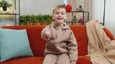 Çocukluk çağındaki çocuk, saçma sapan anekdotlar, komik espriler duyduktan sonra gülerek, kaygısız, olumlu insanların evdeki yaşam tarzlarını hissederek eğleniyor. Oturma odasındaki kanepede oturan genç bir erkek çocuk.