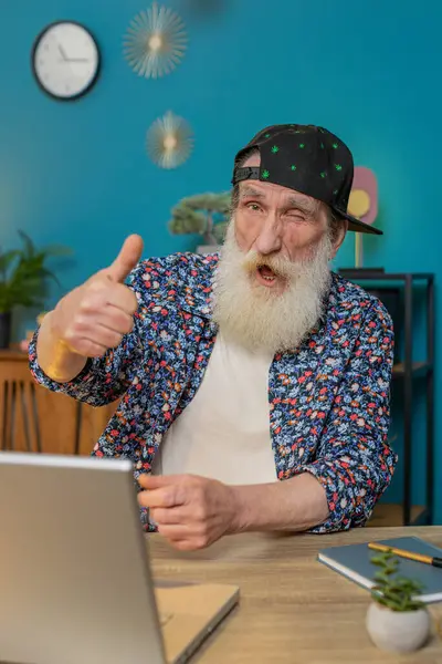 stock image Like. Smiling stylish senior old man looking approvingly at camera showing thumbs up sign positive something good great news positive feedback. Happy elderly grandpa with laptop at home office desk.