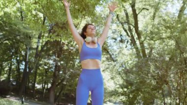 Sportif kaygısız kız yoga meditasyonu yapıyor, pozitif enerji alıyor, sağlıklı yaşam tarzı var. Genç bir kadın, yaz günü parkta dinlenirken nefes egzersizleri yapıyor. Aktif sporcu kadın yaşam tarzı