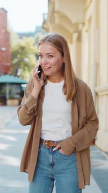 Telefon, iyi haber, dedikodu. Akıllı telefonda hoş sohbetler yapan mutlu, beyaz bir bayan, dışarıda arkadaşlarıyla konuşmaktan zevk alıyor. Şehir caddesinde duran kız. Kasaba yaşam tarzları.