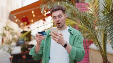 Kafkasyalı bir adam internet üzerinden alışveriş yapmaya çalışırken kredi kartı bloke edilmiş cep telefonuyla şok olmuş. Sokaktaki kızgın erkek turist bankanın reddetme sorununu satın alıyor ödeme eksikliği para dengesi