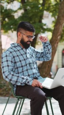 Dizüstü bilgisayarla çalışan mutlu Hintli sakallı adam zafer çığlıkları atıyor. İyi haber başarısını kutluyor. Kumarhane piyangosunun parasını dışarıda kazanıyor. Şehir sokağındaki İspanyol adam. Dikey