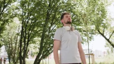 Sakin ol, sakin ol. Sakallı adam meditasyon yapıyor, derin derin nefes alıyor, dua eden gözler kapalı, konsantre düşünceler, dışarıda huzurlu bir zihin. Parkta ağaçların etrafında egzersiz yapan adam..