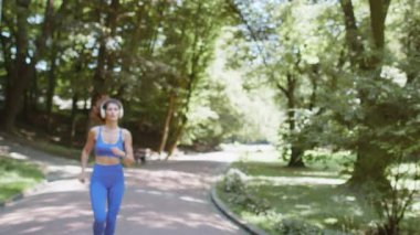 Sporcu spor koşucusu kız yarışmayı bitiriyor. Zafer ve başarı. Parkta kardiyo antrenmanı. Genç bayan koşucu şampiyon maraton kazanıyor. Aktif sporcu kadın motivasyonu.