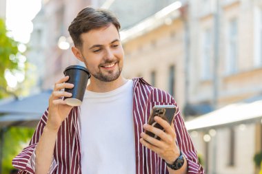 Gülümseyen sakallı adam sabah kahvesini dışarıda içiyor. Dinlenmeye çalışıyorum. Şehir merkezinde yaz güneşi sokağında durup kafeterya kahvesi içen adam. Kasaba yaşam tarzları