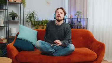 Sakin ol, sakin ol. Müzik dinleyen sakallı genç adam derin derin nefes alıyor, gözleri kapalı meditasyon yapıyor konsantre düşüncelerle, huzurlu zihinle. Genç Kafkasyalı adam evdeki kanepede oturuyor.