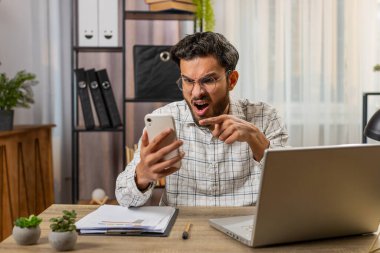 Tartışma. Öfkeli kızgın işadamı, ofisteki hararetli telefon görüşmelerine katılıyor. Sinirli patron hayal kırıklığını cep telefonlu Hintli müdürün astlarıyla tartışarak gösteriyor.