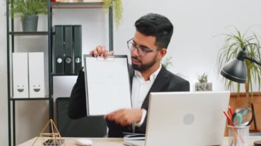 Hintli işadamı internetten video sunumu yapıyor. İş yerindeki uzak öğrenim dersleri için eğitim dersleri alıyor. Takım elbiseli erkek Hindu grafik analizi gösteriyor