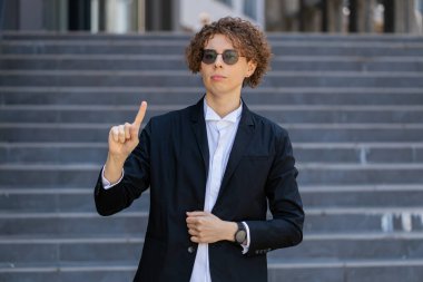 Memnun olmayan Kafkasyalı genç işadamı nahoş, berbat bir fikre tepki veriyor, kötü kaliteden memnun değil, parmağını sallıyor hayır, reddet fikri, evlenme teklifini sevme. Ofis dışında takım elbiseli bir müdür..