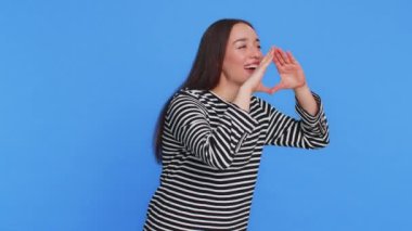 Çizgili bluz giyen mutlu beyaz kadın, kamera tanıtımına, indirimli satış davetiyesi ilanına bağır. Hoş geldin. Heyecanlı gülümseyen kız çığlığı mavi arka planda izole edilmiş.