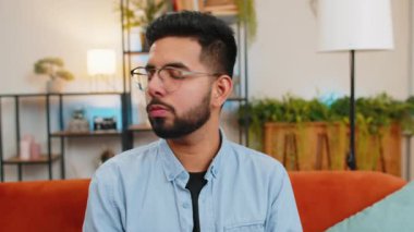 Sessiz olun lütfen. Genç Hintli bir adamın portresi işaret parmağını dudaklara bastırıyor. Sessiz jest işareti yapıyor. Gizli saklı konuşma, gizli mahremiyet. Sınıftaki kanepede oturan adam..