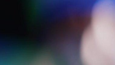 Işık, soyut 4K görüntülerini sızdırır. Yanıp sönen çember mercek parıltısı bokeh, bulanık renk arkaplanının odaklanmamış doğal animasyonunu örtüyor. Çekimleriniz üzerinde birleştirme, videoyu biçimlendirme, geçişler