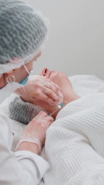 Güzellik yaşlanmayı önleyici enjeksiyonlar biyo-evrizasyon boyun mezoterapisi ile karşılaşıyor. Kozmetik doktoru, genç bir kızın derisine hiyalüronik enjeksiyon yapıyor. Klinikte prosedür terapisi