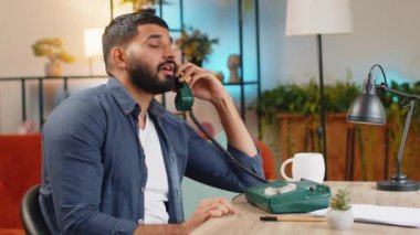 Yorgun, sakallı, serbest çalışan bir Hintli, merkez ofisteki eski model telefondan konuşuyor. İlgisiz İspanyol yönetici yardım hattıyla can sıkıcı bir konuşma yapıyor..