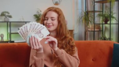 Başarılı beyaz kadın Ukraynalı Hryvnias UAH para fanı koltuğunda oturuyor ve elinde sallıyor. Çevrimiçi piyango oyunu kazanan mutlu kız tatil planlama bütçe kavramı