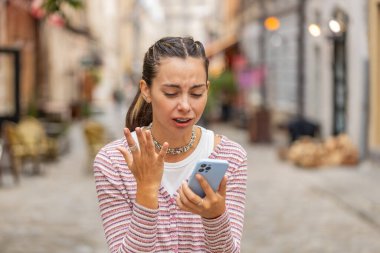 Akıllı telefon daktilosu kullanan genç bir kadın aniden piyango şokunu kaybeder. Kötü haber kaybı uygulaması başarısız virüs hırsızlığı. Şehir sokağında duran üzgün turist kız..