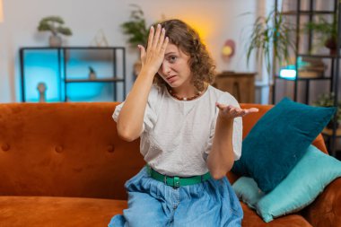 Avuç içi. Yazıklar olsun sana. Üzgün bir kadın saygısız bir jest yapıyor. Başarısız olmaktan sıkılmış olması kötü haber doğuruyor. Oturma odasındaki kanepede oturan kızın portresi. Yaşam tarzları. Yaşam Tarzları.