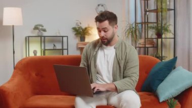 Evdeki koltukta oturan yorgun, kafkas bir adam dizüstü bilgisayar kullanıyor ve stresli. Şok olmuş esmer adam kaybına tepki veriyor, Netbook 'ta kötü haber oturma odasında. Bilgisayar virüsü.