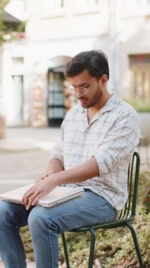 Sandalyede oturan Hintli serbest yazar dizüstü bilgisayarını açar teneffüste internet üzerinden iş arama web sitesinde sohbet etmeye başlar. Genç adam netbook ekranına bakıyor, mesajlar gönderiyor, film izliyor..