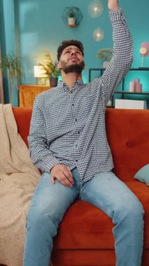 Komşularda tamirat. Sinirli Hintli genç adam, gürültülü müzik komşularının baş ağrısından rahatsız olduğu yastıklarla kulaklarını kapatıyor. Evde ses yalıtımı olmayan ince duvarlar.