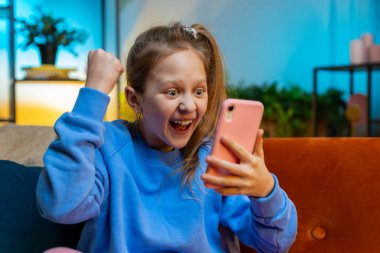 Mutlu çocuk kız cep telefonu daktilo kullanıyor. İnternette yazı yazıyor. Büyük bir sürpriz, güzel bir pozitif haber. Akşamları beyaz çocuk evinde, odasında kanepede oturuyor.