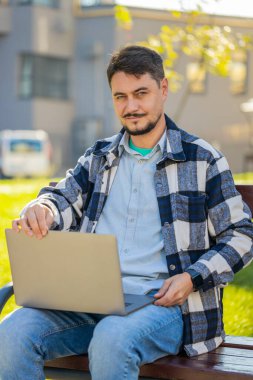 Kafkasyalı serbest çalışan, internette uzak bir işte çalışan, dizüstü bilgisayarlı, şehir sokaklarındaki internet sitelerinde takılan internet sohbetleri yapan bir adam. Netbook ekranı kullanan mutlu adam film izleyen mesajlar gönderiyor.